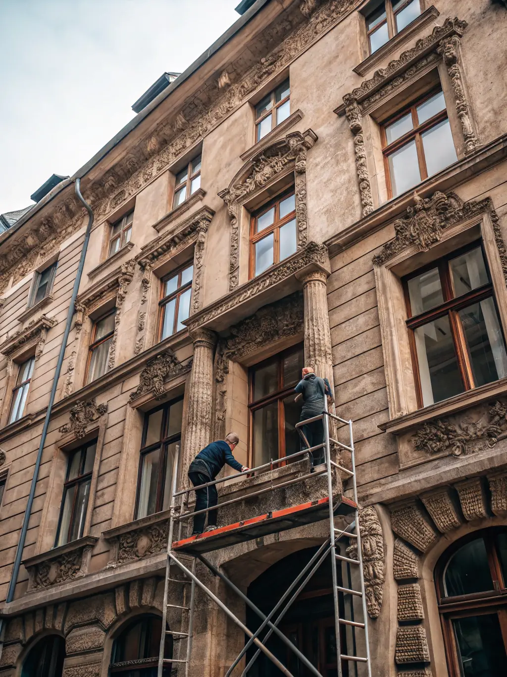 A photograph depicting the restoration of the Luxé church's exterior stone facade, showcasing scaffolding, workers carefully cleaning the stone, and before-and-after shots highlighting the improvement.