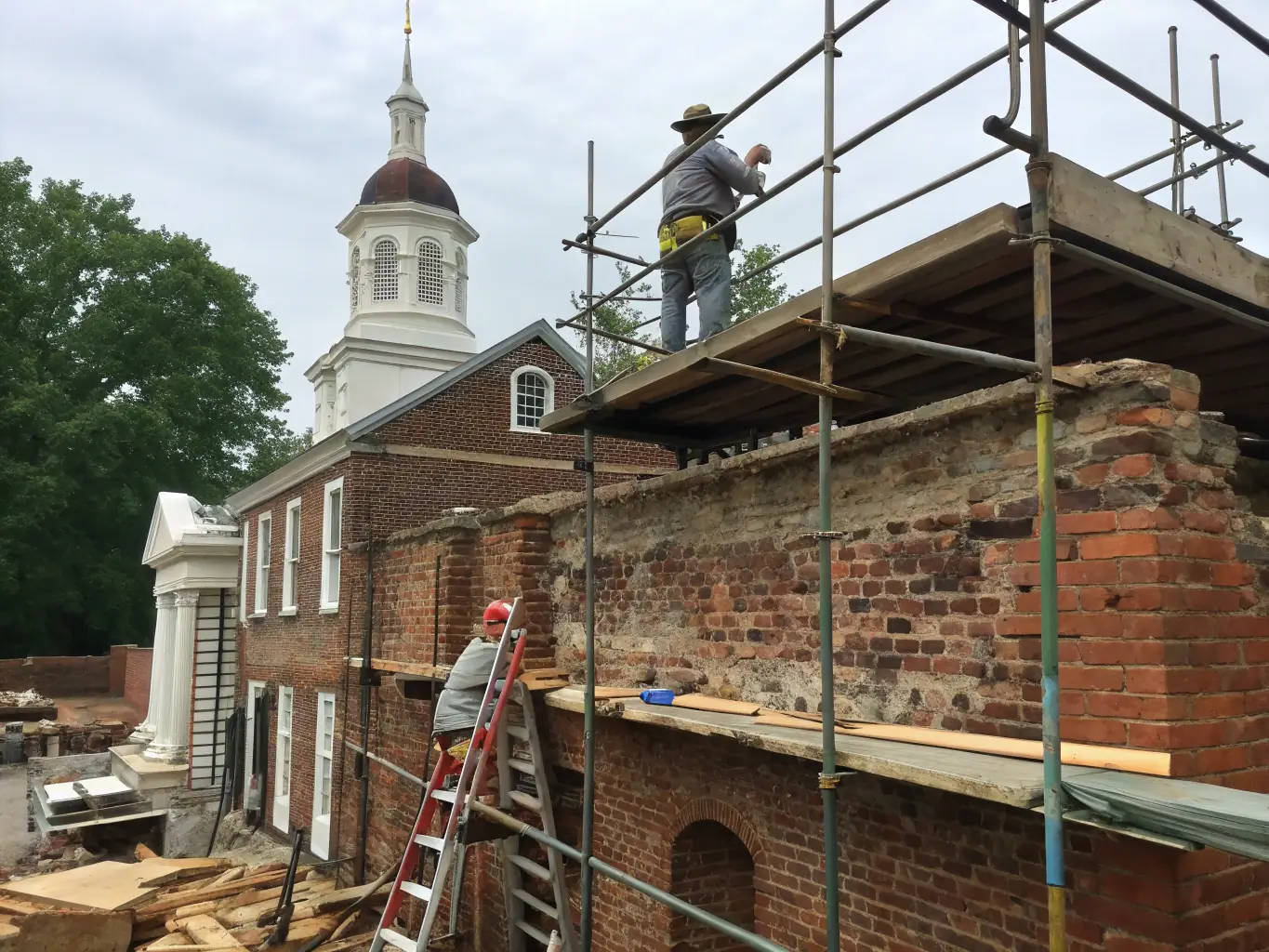 An expert artisan carefully repairing a damaged section of a historic building, using traditional techniques and materials to ensure authentic restoration.